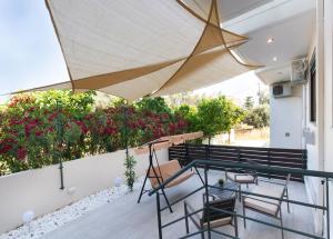 a patio with a table and chairs under a umbrella at Sofoklis City House with a private Veranda by Imagine Lefkada in Lefkada