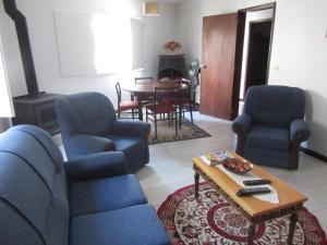 a living room with blue chairs and a table at Casa Eira do Povo in Vale de Colmeias