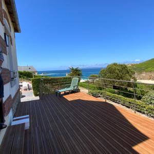 a wooden deck with a bench on top of a house at Magnifique villa face à la plage de Pors Peron in Beuzec-Cap-Sizun