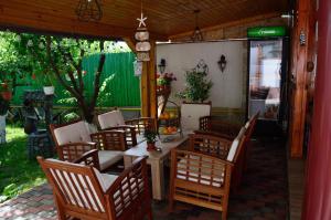 a patio with a table and wooden chairs at Helen Rooms Vama Veche in Vama Veche