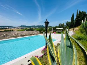 a swimming pool with a street light and plants at Villa Poggio Ulivo Pool-Apartments in Rivoli Veronese