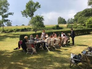 een groep mensen die aan tafels in het gras zitten bij Gæstgiveri Bregninge in Ærøskøbing