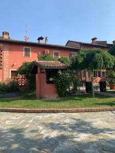 um edifício laranja com um alpendre num quintal em La vecchia Cascina Rossa em Fubine