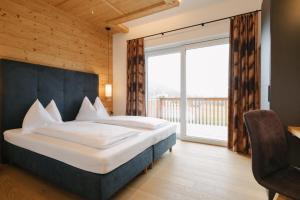 una camera con un grande letto e una grande finestra di Chalet Village by Apart4you a Ramsau am Dachstein