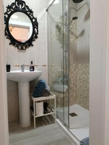 y baño con lavabo y ducha con espejo. en Acogedor apartamento cerca del centro histórico de Málaga, en Málaga
