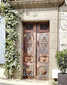 una antigua puerta de madera en el lateral de un edificio en L'Oiseau Bleu PEACOCK, en Roubia