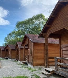 a row of wooden cabins in a row at Gyopar Wooden Houses in Izvoare