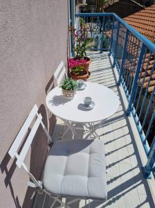 - Balcón con mesa blanca y sillas en Samothrakis Michelangelo 301, en Samotracia