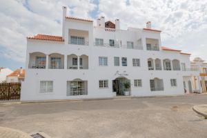 a large white building with a large window at VILLA EIRA Boutique Houses - ex Casa da Eira in Vila Nova de Milfontes