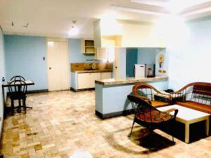 a kitchen with a couch and a table and chairs at Benson Hotel San Juan CIty in Manila