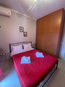 a bedroom with a red bed with two napkins on it at dimitris house 2 in Alepou