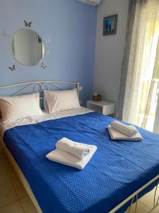 a blue bed with two towels on top of it at dimitris house 2 in Alepou