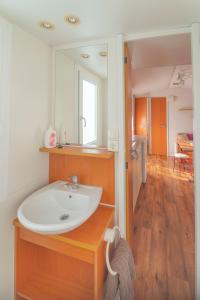 W łazience znajduje się umywalka i lustro. w obiekcie Hoamat#am#See w mieście Seekirchen am Wallersee