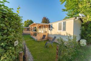 een huis met een veranda en een stoel in de tuin bij Hoamat#am#See in Seekirchen am Wallersee