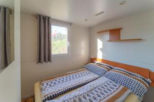 a bedroom with a bed with blue pillows and a window at Hoamat#am#See in Seekirchen am Wallersee