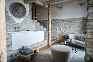 ein Wohnzimmer mit einem weißen Sofa und einer Ziegelwand in der Unterkunft Boutiquehotel Blaue Burg Falkenstein in Pfronten