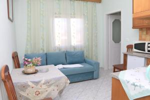 a living room with a blue couch and a table at Isabela Apartments in Sarandë