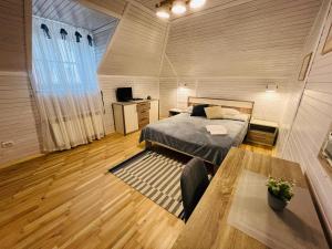 Un dormitorio con una cama y una mesa. en Гостерія"Old Town" en Kamianets-Podilskyi