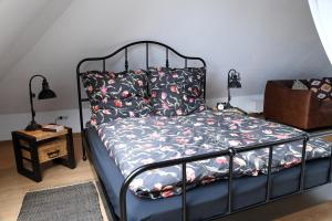 a bedroom with a bed with a black frame and pillows at Loft-Style-Living Schütt - einfach anders in Monschau