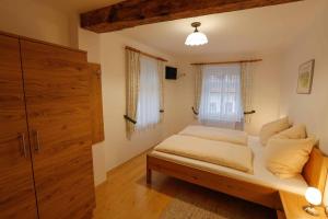 ein kleines Schlafzimmer mit einem Bett und einem Fenster in der Unterkunft Gästehaus Huber in Weissenkirchen in der Wachau
