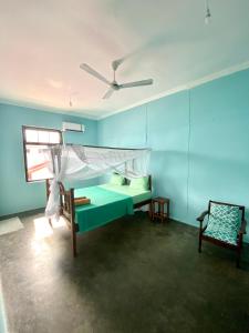 a room with a bed and a ceiling fan at Balcony House in Zanzibar City