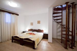 ein Schlafzimmer mit einem Bett und einer Wendeltreppe in der Unterkunft Apartments With View in Adamas