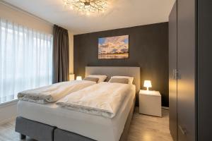 um quarto com uma cama grande e um lustre em The Palmtree em Zandvoort