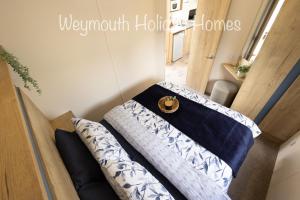 a room with a couch in a tiny house at 2021 2 Bedroom Deluxe Caravan Sleeps 6 with WI-FI in Wyke Regis