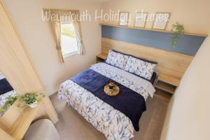 a bedroom with a bed with a wooden headboard at 2021 2 Bedroom Deluxe Caravan Sleeps 6 with WI-FI in Wyke Regis