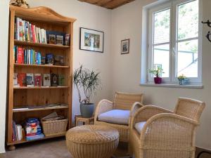 a living room with two chairs and a book shelf at Gästehaus Huber in Weissenkirchen in der Wachau