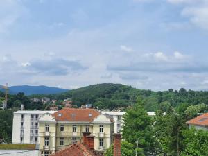 un groupe de bâtiments avec des montagnes en arrière-plan dans l'établissement Le Soleil Apartman Vrnjačka Banja, à Vrnjačka Banja