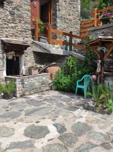 een stenen patio met een blauwe stoel en een gebouw bij Fiocco di Neve in Montjovet