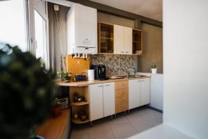 a kitchen with white cabinets and a window at Vila RANYA - Adults Only in Mangalia +21 photos