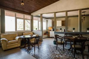 a kitchen and living room with tables and chairs at Vila RANYA - Adults Only in Mangalia