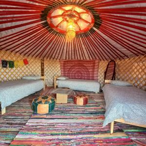 a room with two beds in a yurt with a ceiling at Casa de la Vida Málaga in Pizarra