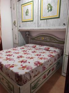a bedroom with a bed with a floral bedspread at Sa Marinedda Guest Apartment - self check-in - IUN R1644 in Olbia