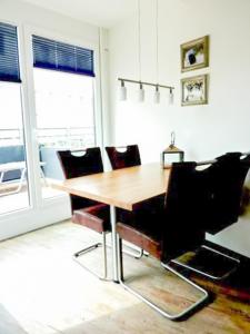 - une salle à manger avec une table et des chaises en bois dans l'établissement Seebox Appartment 3, à Norderney