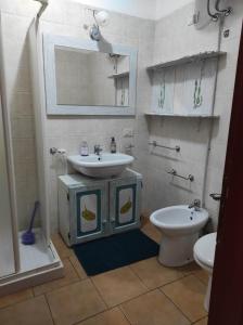 a bathroom with a sink and a toilet and a mirror at Sa Marinedda Guest Apartment - self check-in - IUN R1644 in Olbia