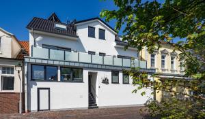 a white house with a black roof at Louise am Meer in Norderney