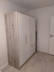 a large white cabinet in a room with wooden floors at Ferienwohnung in Beelitz Heilstätten in Beelitz