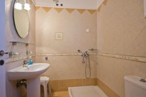 ein Badezimmer mit einem Waschbecken, einem WC und einem Spiegel in der Unterkunft Apartments With View in Adamas