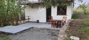 a table and chairs in front of a house at La finestra sul vigneto in Castiglione di Sicilia