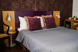 a bedroom with a bed with purple and white pillows at Vila RANYA - Adults Only in Mangalia