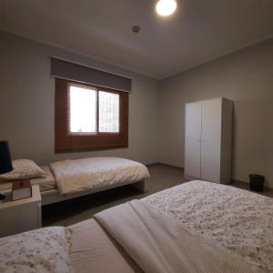 a bedroom with two beds and a window at سن رايز in King Abdullah Economic City