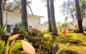 a yard with a house and trees and plants at Cabedelo Beach House in Viana do Castelo