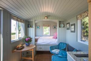 チェスターにあるLittle Idyll shepherds hutのベッドとテーブル付きの小さな部屋