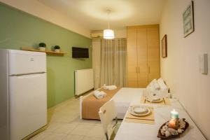 a small room with a bed and a refrigerator at Sunny Central Studio in Zakynthos Town