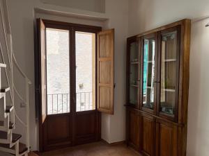 Pokój z drewnianymi drzwiami i oknem w obiekcie La Rupe Apartments Tropea w Tropei
