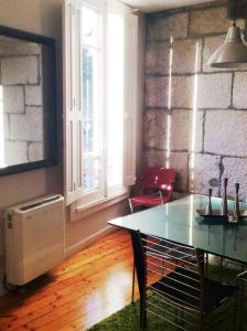 Habitación con mesa, sillas y pared de ladrillo. en Acogedor apartamento en el Casco Antiguo, en Vigo