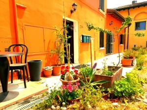a patio with plants and a table and a building at ZANINA COUNTRY HOUSE in Peschiera del Garda